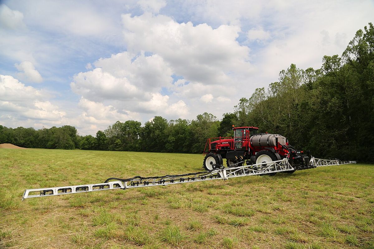Self-propelled sprayer with booms unfolded in a paddock